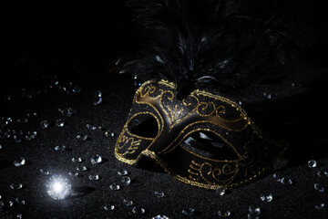 Carnival gold mask with diamonds on black background.