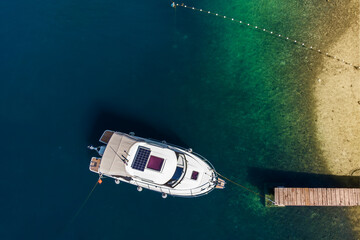 Top above drone view moored sailboat boat yacht  moored wooden pier turquoise sea water background....