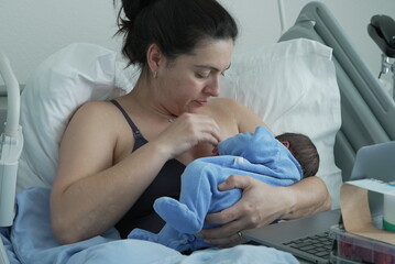 A detailed shot of a mother breastfeeding her newborn baby, showcasing the intimate bond and...