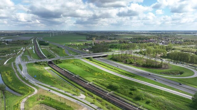 Drone of the vehicles driving on a highway under bridge and railway track in the view on a sunny day