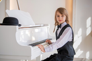 A young boy is playing the piano .