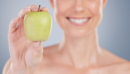 Beauty, diet and apple in hand closeup for nutrition benefits in studio background with wellness....