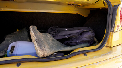  Dirty rubber boots lying in the trunk of the car. concept: rude and careless attitude towards...