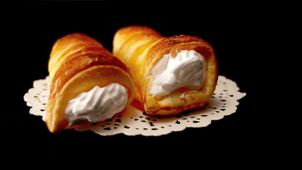 sweet tubes with white cream on black background