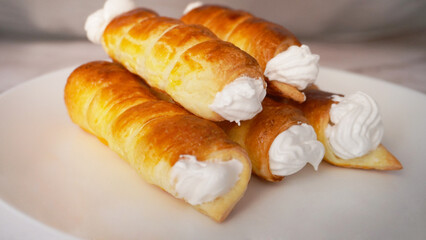 
sweet tubes with white cream on a plate