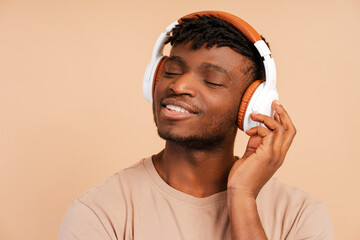 Closeup, happy african american man wearing wireless headphones listening to music