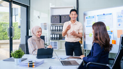 Comprehensive financial chart adorns the whiteboard during a presentation, where male and female...