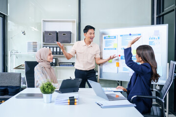 Comprehensive financial chart adorns the whiteboard during a presentation, where male and female...