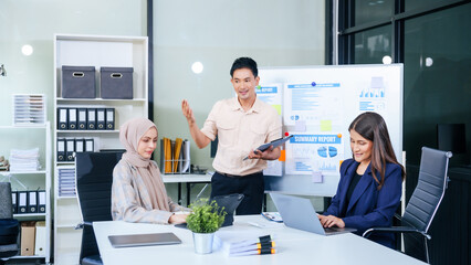 Comprehensive financial chart adorns the whiteboard during a presentation, where male and female...