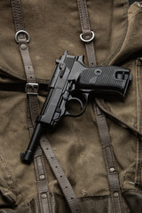 German vintage 9mm pistol from the Second World War. Background from an old canvas military backpack.