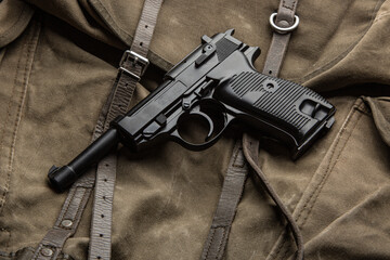 German vintage 9mm pistol from the Second World War. Background from an old canvas military backpack.