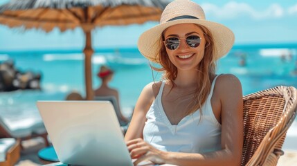 Portrait of happy Young tourist woman sitting on chair at the beach cafe and using a laptop on table