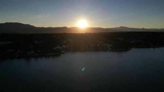 Aerial view of Tequesquitengo lake with the sun-setting over the mountains in the background, Mexico