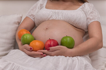 woman with fruits. woman holding fruit. Pregnant  with  apple. and orang.