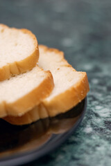 Food ingredients like slices of meat and bread served on black plate