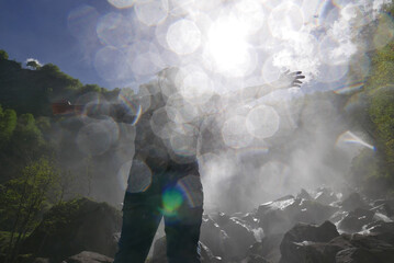 unrecognizable person under alpine waterfall in Bavona Valley