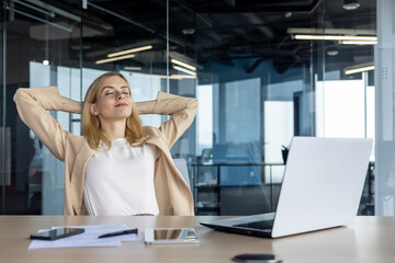 Relaxed businesswoman taking a break at office desk with eyes closed