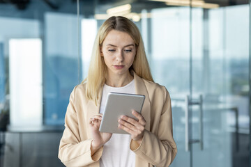 Confident businesswoman using tablet in modern office environment