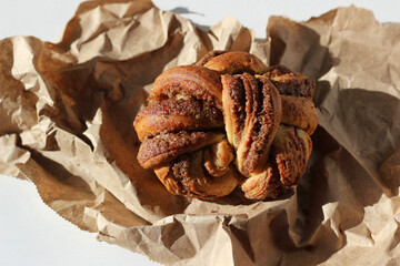 Fresh Cinnamon Bun on Parchment Paper. Bakery.