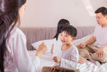 Fototapeta premium A family of four in bed in the bedroom