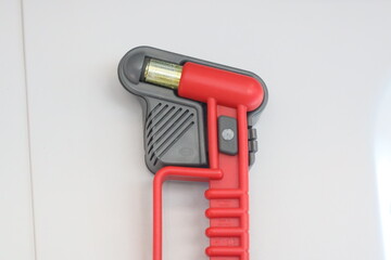 Red and black pipe cutter tool on a white wall. Ideal for plumbing projects