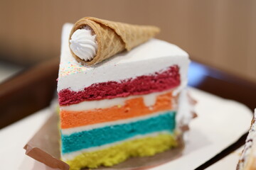 Delicious piece of cake with a sweet ice cream cone on top. Perfect for dessert menu designs