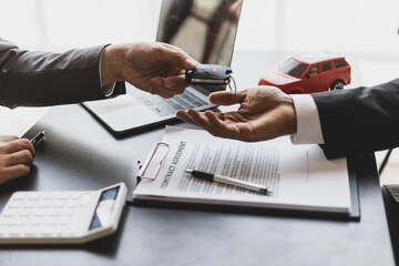Customer signing car purchase or lease contract agreement with car salesman, car insurance.