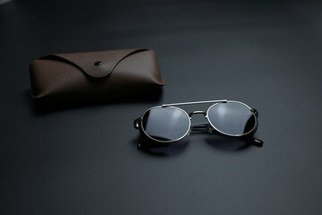 vintage sunglasses with brown case on gray background