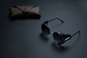 vintage sunglasses with brown case on gray background