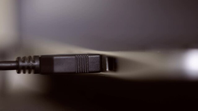 Usb hdd connected to a laptop. Hand disconnecting black USB cable to computer. Plug / unplug USB cable to laptop. Usb hdd connected to a netbook. 4K (UHD).  Macro shot 