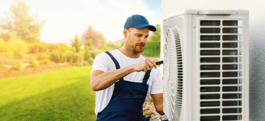 technician working on house air conditioning or heat pump outdoor unit. HVAC service, maintenance...