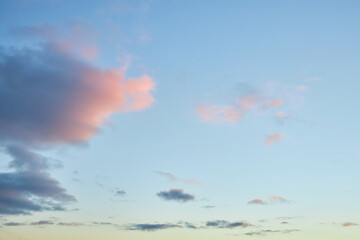 A fragment of a bright sunset sky with bizarrely shaped clouds