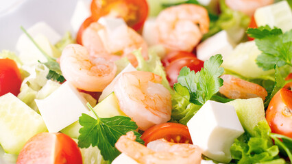A close-up salad of fresh vegetables, a plate of fresh salad with vegetables and herbs. Greek salad with juicy tomatoes, feta cheese lettuce leaves green olives cucumber, fresh parsley. Homemade food.