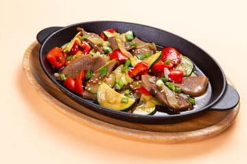 Fried beef tongue with vegetables in a plate.