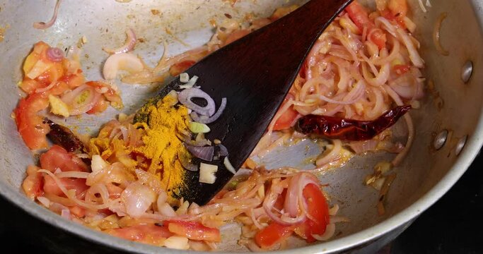 Saut&eacute; frying tossing tomato onion garlic cumin red dry chilli spice in hot oil saucepan cooking for dal tadka bagar 