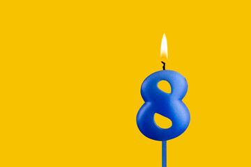 Blue birthday candle on yellow background - Number 8