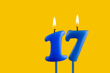 Blue candle number 17 - Birthday on yellow background