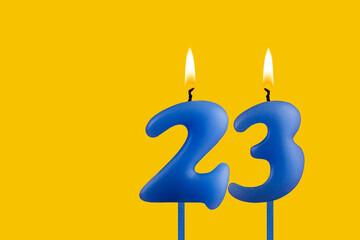 Blue candle number 23 - Birthday on yellow background