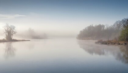 Obraz na płótnie Canvas A misty morning on the river with fog hovering ju