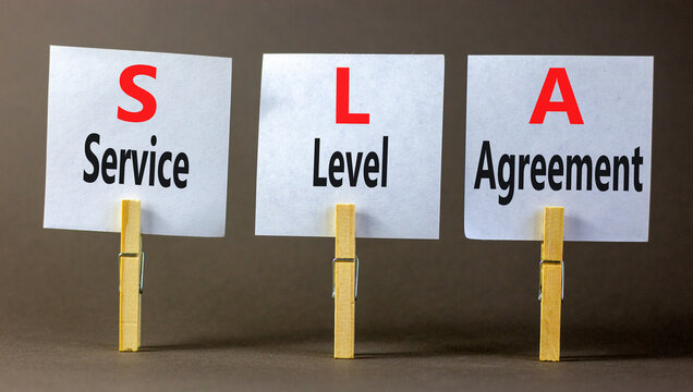 SLA service level agreement symbol. Concept words SLA service level agreement on beautiful white paper. Beautiful grey background. Business SLA service level agreement concept. Copy space.