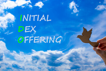 IDO initial DEX offering symbol. Concept words IDO initial DEX offering on beautiful blue sky...