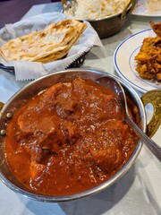 Traditional Indian Meal in Restaurant Setting with Curry and Naan