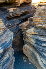 The narrow volcanic gorges and fissures of The Cracks ( Las Grietas ) . The slope of the Montana Blanca volcano. Lanzarote, Canary Islands, Spain