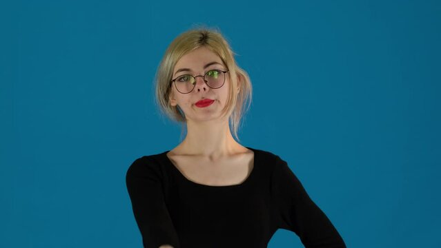 Businesswoman stretches out arm pressing buttons on remote. Female worker navigates settings with determined look in office