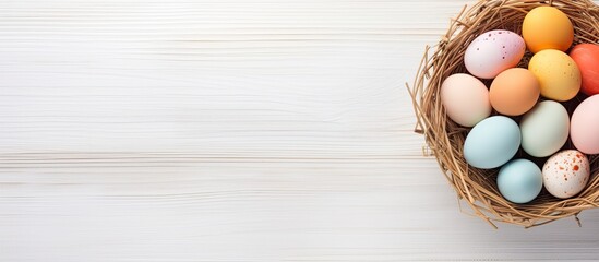 A top down view of an Easter greeting card showcasing a delightful arrangement of vibrant eggs nestled in a basket on a white wooden table providing ample copy space for personal greetings