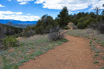 winding hiking trail with a view of the range and cloudy sky