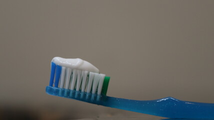 A plastic toothbrush with toothpaste in a bathroom