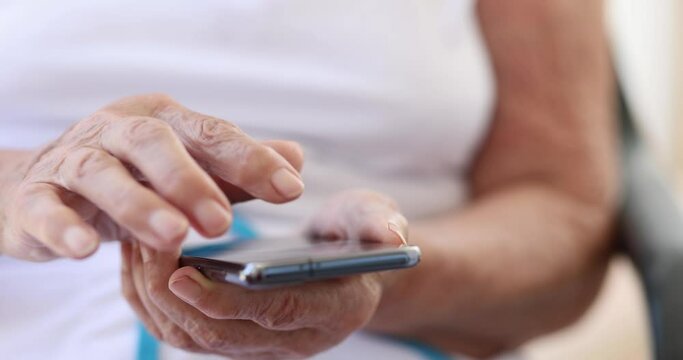 Elderly woman uses smartphone and mobile applications for pensioners. Family chatting concept