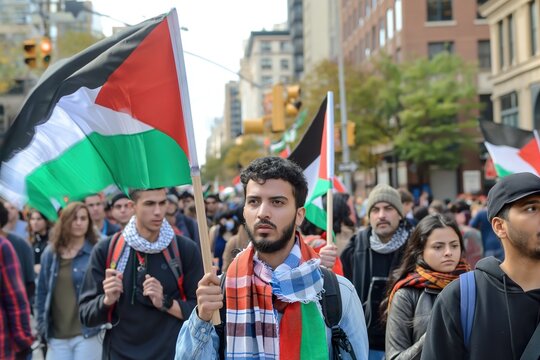 People  march holding Palestinian flags on a city street.