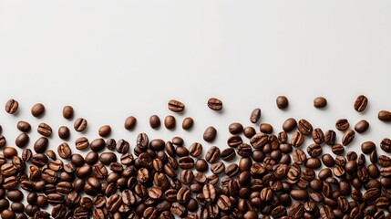 Coffee beans scattered on a plain white surface
